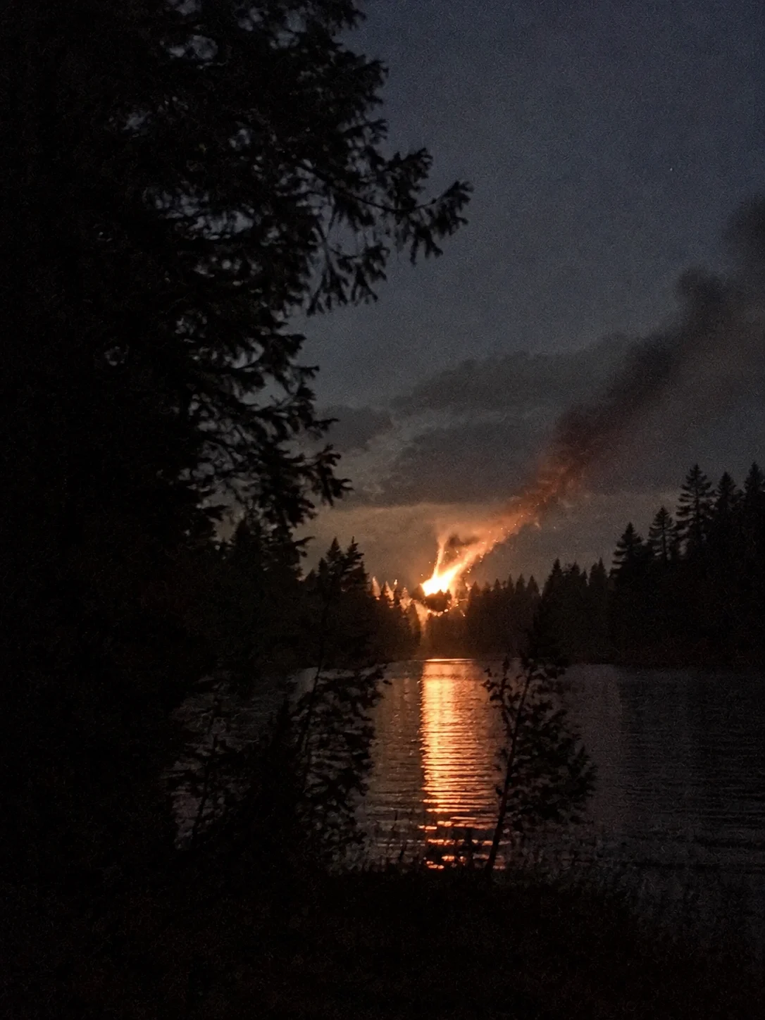 Illustration of a burning object streaking down toward a lake at dusk