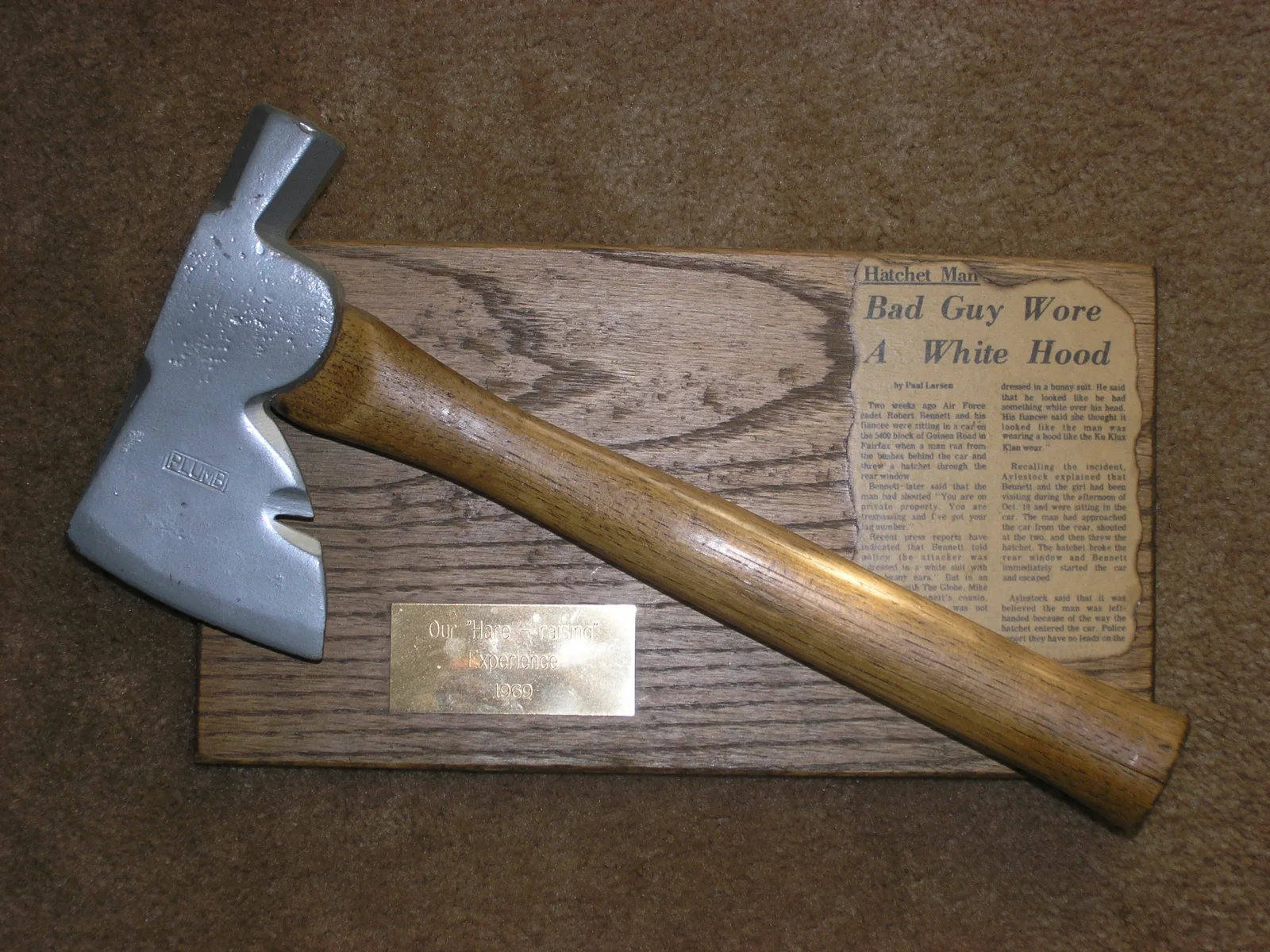 Hatchet mounted on a plaque beside a newspaper clipping